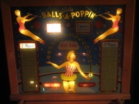 Image # 29183: Balls-A-Poppin Illuminated Backglass 
(Visible on each side of the lady's head are the reflections of the lamps positioned under the apron. Serial number B1710.)