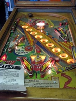 Image # 52399: Rocket Illuminated Playfield 
(The triangular post between the flippers is not original, and would be round. The red flipper above this post is not original and we do not know if it operates. The posts in the lower left and right corners of the playfield have been moved from their original positions.)