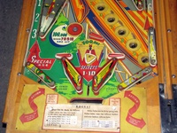 Image # 52402: Rocket Lower Playfield 
(The triangular post between the flippers is not original, and would be round. The red flipper above this post is not original and we do not know if it operates. The posts in the lower left and right corners of the playfield have been moved from their original positions.)