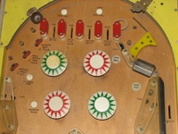 Image # 41030: See Saw Whitewood Upper Playfield 
(Near the exposed light bulbs are penciled circles suggesting where the bulbs ought to be. The loose ball guide rubber would be fitted around a post missing from the nearby screw hole.)