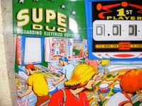 Image # 49824: Super Duo Backglass - Detail 
(The white 'backglass' area on the left allows the player to record the latest high score in that space. Serial number 04002.)