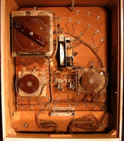 Image # 64749: World Champ Inside Backbox 
(A round hole in the insert can barely be seen just below the M-relay that is below the replay wheel. This hole was intended for a lamp for 'Game Over' Illumination but the socket was not wired in the production run. A bell is missing from the 0-9 unit on this particular game. The brown eyelet screw above the replay unit is not original to this game.)