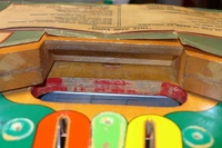 Image # 63518: Hits and Runs Outhole Trough And Serial Number 
(The serial number A1283 is stamped on the playfield.)