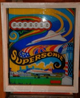 Image # 55882: Supersonic Alternate Backglass - No Lines 
(The wings of the flying Concorde lack the blue and gold lines found on other backglasses. The tower wall lacks the artful lines to indicate individual bricks. Serial number 00120.)