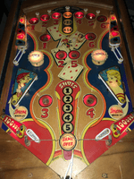 Image # 75422: Canasta Illuminated Playfield 
(This playfield is missing the two flipper-shaped posts at the very top center of the playfield, above the white post, and where a rubber ring fits around all three of them.)