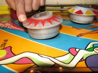 Image # 59678: Carnival Pop Bumper Activation 
(The pop bumper is manually operated to simulate a ball hitting it from the direction of the upper playfield. A nearby pop bumper is in normal position. Serial number 0400.)