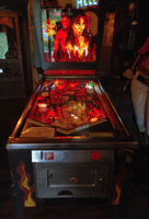 Image # 82770: Hell Illuminated Front View 
(This game contained no LEDs but an illumination problem caused some backglass bulbs to shine too brightly for this picture, causing halos on the woman.)