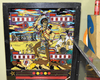 Image # 76769: Sherokee Backglass 
(On the right, the playfield glass in its hinged frame has been raised to its service position.)