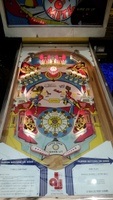 Image # 67916: Dyn O' Mite Illuminated Playfield - Glass On 
(The bumper cap and apron cards are reproduction. The flippers are a later version from this manufacturer where screw heads and washers are not visible. Decals were added to simulate the original flippers.)