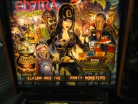 Image # 50878: Elvira and the Party Monsters Illuminated Backglass with Modesty Decal 
(The decal is included with the game to be applied by the operator if desired.)
