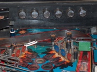 Image # 54049: F-14 Tomcat Early Production - Flash Lamp Insulators 
(Serial number 554 95836. The green spinning target has little relative wear for the age of this game and is deemed a replacement. The red target on the right likely replaced an original blue one. A 2-inch white rubber ring probably should replace the two smaller rubber rings shown here between the standup targets, to encircle all three posts.)