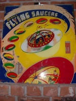 Image # 7870: Flying Saucers Backglass 
(The rectangular window on the right side of the backglass allows the player to view a pendulum tilt.)