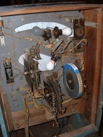 Image # 58737: Flying Saucers Inside Backbox 
(Blue tape on the replay wheel holds new and old numbered strips. The knocker can be seen in the upper left area.)
